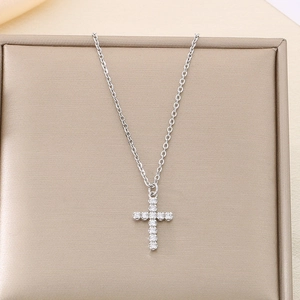 Detail of silver stainless steel necklace with crystal-studded cross on jewelry box