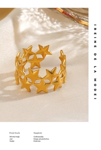 Detail view of gold stainless steel star open ring on elegant white silk background