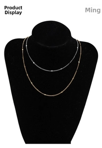 Detail of minimalist double-layer 18k gold and silver stainless steel chain necklace