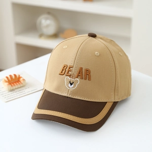 Detailed embroidery of a bear logo on a two-tone khaki and brown kids baseball cap