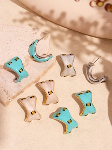 Detailed view of colorful enamel stainless steel earrings on a textured stone surface