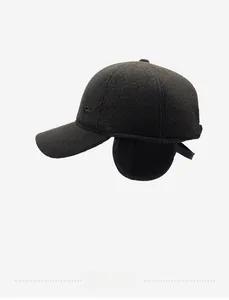 Detail view of winter wool baseball cap with earflaps and metal logo in dark grey