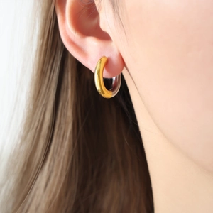 Close-up of minimalist two-tone chunky hoop earrings in gold and silver finish