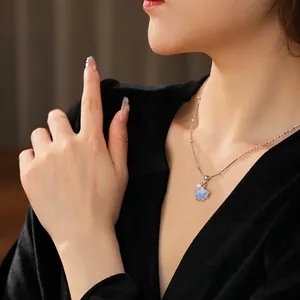 Blue star necklace with crystal texture and pearl detail worn by model on black velvet
