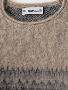 Close-up detail of light brown mohair knit sweater with grey geometric jacquard pattern