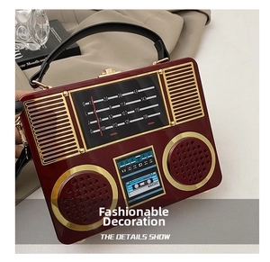 Macro detail of the vintage radio handbag showing deep wine red finish and gold metal accents