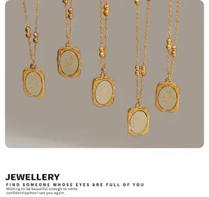Detailed close-up of 18K gold plated rose relief rectangular pendants on beaded chains