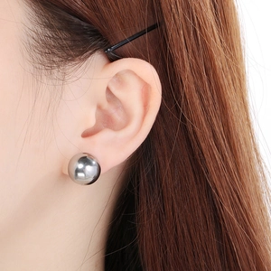 Close-up of minimalist gold-plated round stud earring worn on a model's ear