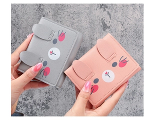 Close-up of cute cartoon rabbit wallets in grey and pink PU leather with ear detail