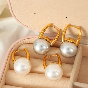Elegant gold U-shape hoop earrings with white and grey pearls in a pink jewelry box