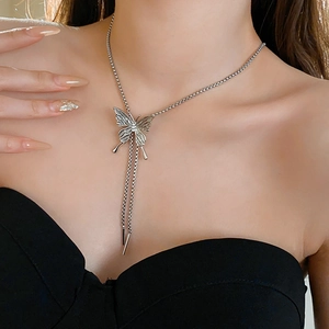 Detail of silver butterfly tassel necklace on model highlighting the elegant Y-shape design