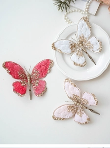 Detailed view of plush butterfly clips with gold glitter and pearls for Christmas trees