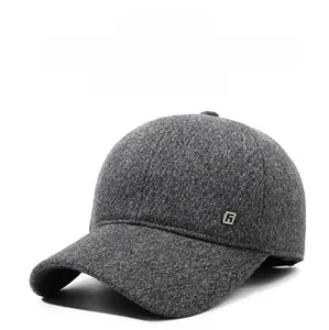 Detail of dark gray winter baseball cap showing wool fabric and square metal logo