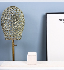 Detailed close-up of golden hollow metal jewelry stand and beige velvet display base