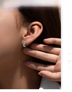 Close-up of polished S925 sterling silver hoop earring worn on model ear