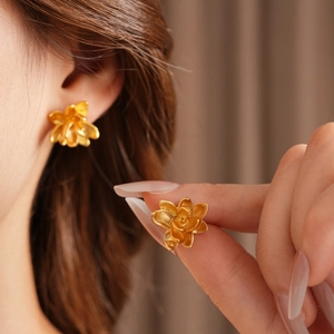 Detail van vintage gouden lotus oorknopjes met matte textuur en gepolijste afwerking