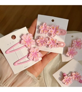 Detail of pink cherry blossom hair clips with resin petals and yellow stamens