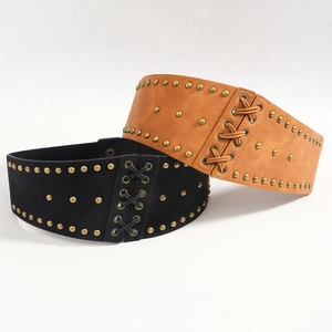 Fashionable wide waist belts in black and brown faux leather with brass rivets and lace-up design