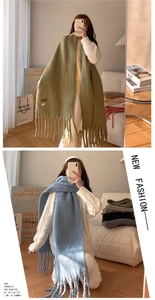 Detail of thick knit scarf with long tassels in macaron green and soft blue colors