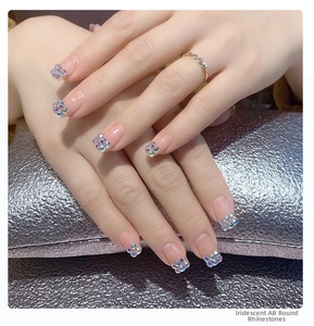 Detailed view of Aurora AB round rhinestones applied on fingernails for nail art decoration