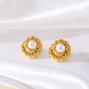 Retro golden twisted hoop earrings with white round pearls on white silk background