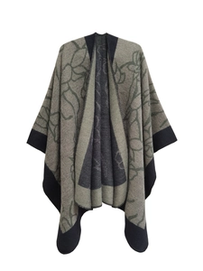 Detail of grey-green knit shawl with black borders and abstract floral jacquard patterns