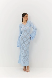 Dettaglio macro dell'abito in maglia azzurro con scollo a V e motivi geometrici traforati
