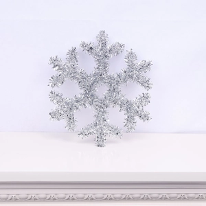 Macro detail of a silver glitter snowflake ornament with intricate tinsel texture