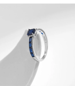 Studioaufnahme des S925 Silberrings mit blauem Saphir auf einem minimalistischen Ständer