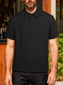 Détail d'un polo noir en maille montrant la texture, le col et les trois boutons