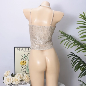 Detail of champagne gold sequined camisole with open back straps on a mannequin