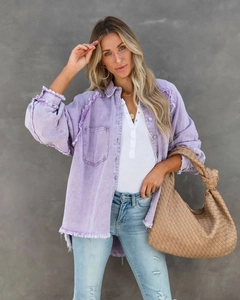 Detail einer lila Oversize-Jeansjacke mit ausgefransten Säumen und Vintage-Waschung
