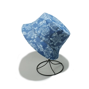 Close-up of blue rose floral print denim bucket hat on a professional display stand