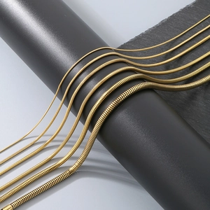 Versatile gold titanium steel snake chains in multiple thicknesses on a dark display stand