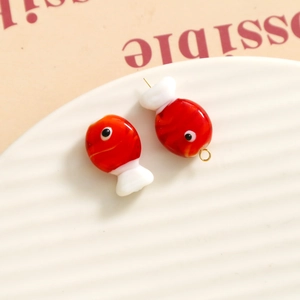 Detail view of a red and white 3D fish glass bead pendant with metal loop for DIY jewelry