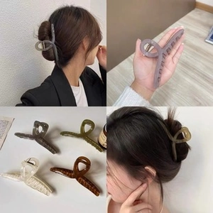 Detailed views of four large hair claws in translucent gray, olive green, cream, and tortoiseshell