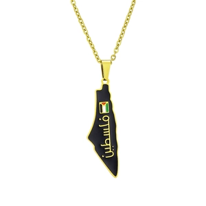 Macro shot of gold-plated map pendant with black oil drip and Arabic calligraphy detail
