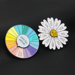 Detail of colorful enamel decision-maker wheel pins showing food options and daisy motif