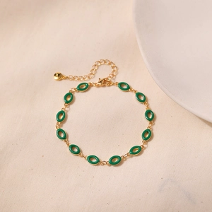 Detail view of gold-plated chain link bracelet with green enamel ovals and lobster clasp