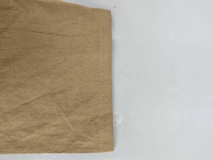 Macro shot of khaki linen fabric showing double-needle stitching and texture detail