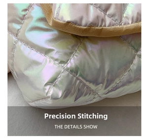 Detailed close-up of precision stitching on iridescent silver quilted fabric with beige trim