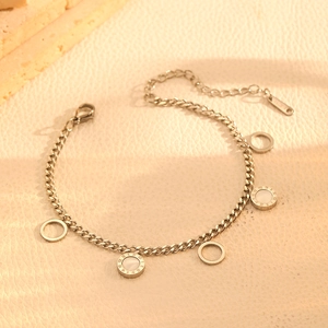 Detailed close-up of a silver stainless steel bracelet with roman numeral round charms