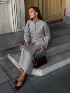 Women's chic grey knitted cardigan and skirt set styled in an elegant outdoor setting