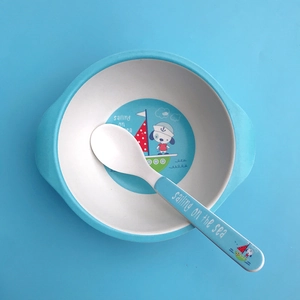 Detail von Kindergeschirr aus Bambusfaser mit blauem Cartoon-Seemannshund und Löffel