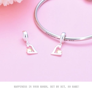 Macro shot of S925 silver heart charms on bracelet with 'Unique as you are' engraving