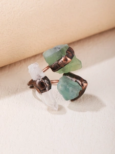 Macro shot of three raw green fluorite and clear crystal stones in bronze punk ring