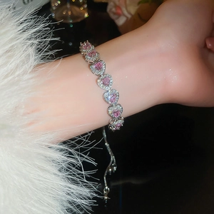 Detail of pink heart gemstone bracelet with silver-tone chain on wrist