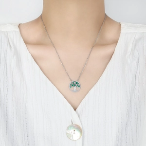 Bohemian Tree of Life necklace with green zircon accents worn on a model with white shirt