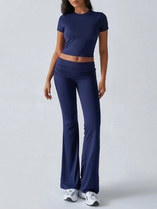 Detail of high-waist navy blue flare trousers and short sleeve crop top set