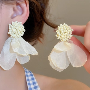 Macro detail of large organza flower earrings with cream beads for non-pierced ears